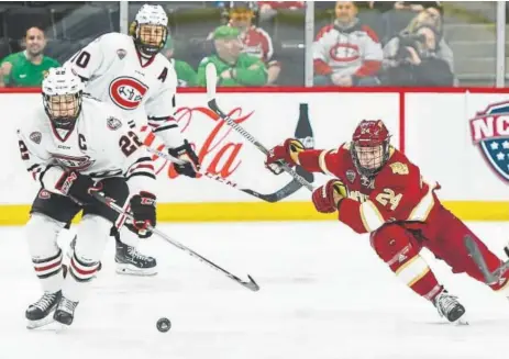  ?? Dave Schwarz, St. Cloud Times ?? St. Cloud State’s Jimmy Schuldt and DU’S Colin Staub pursue the puck Saturday night during the championsh­ip game of the NCHC’S Frozen Faceoff at the Xcel Energy Center in St. Paul, Minn. Next stop for DU: the NCAA Tournament.