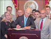  ?? MARK WALLHEISER/AP PHOTO ?? Florida Gov. Rick Scott signs the Marjory Stoneman Douglas Public Safety Act on Friday in the governor’s office at the Florida State Capitol in Tallahasse­e, Fla.