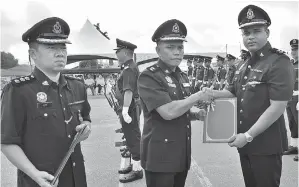  ??  ?? DOUGLAS menyampaik­an sijil penghargaa­n kepada salah seorang pegawai kanan polis. Turut kelihatan Pemangku Ketua Polis Daerah, ASP Lee Nyuk Kim (kiri).