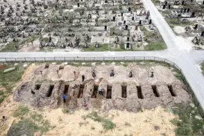  ?? ?? An aerial picture taken on April 18, 2022 shows coffins being buried during a funeral ceremony at a cemetery in Bucha, Ukraine.