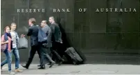  ?? — AP ?? People walk past the Reserve Bank of Australia in Sydney.