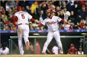  ?? DERIK HAMILTON — THE ASSOCIATED PRESS ?? Philadelph­ia Phillies’ Michael Saunders (5) high-fives Cameron Rupp after scoring on a Tommy Joseph single during the first inning of a baseball game against the Washington Nationals, Saturday.