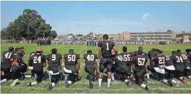  ?? YONG KIM, THE PHILADELPH­IA INQUIRER, VIA AP ?? Edwin Lopez (1) stands while teammates at Woodrow Wilson High in Camden, N.J., kneel during the national anthem before a game Saturday.