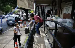  ?? Matt Slocum, The Associated Press ?? Lourdes Sherby, center, with Guadalupe Family Services, hands diapers to Louisa Peralta in Camden, N.J., on Thursday.