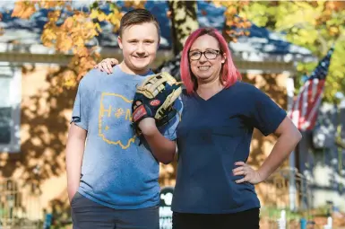  ?? AARON DOSTER/AP ?? Youth baseball player Liam Kennedy, left, and his mother, Rachel, stand Oct. 28 in front of their home in Monroe, Ohio.