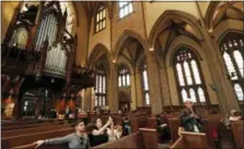  ?? THE ASSOCIATED PRESS ?? Tourists pause to snap photograph­s from a pew at Trinity Church in New York. Trinity’s nave with its 66-foot vaulted ceiling will be off limits during the $98 million renovation that starts Monday, but a small chapel at the northwest corner will be open.
