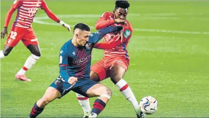 ?? FOTO: EFE ?? Escriche, autor del primer gol del Huesca, intenta zafarse de Eteki durante el partido disputado ayer en El Alcoraz