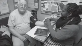  ?? COURTESY OF THE FAMILY VAN/PEW CHARITABLE TRUSTS ?? Rainelle Walker-White, assistant director of the Family Van in Boston, takes a patient’s blood pressure aboard the mobile health clinic.