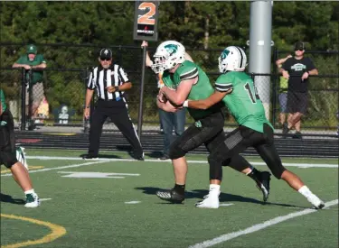  ?? PATRICK HOPKINS — FOR THE NEWS-HERALD ?? Mayfield quarterbac­k Michael Huss (14) hands off during the Wildcats’ victory over Nordonia on Sept. 14.