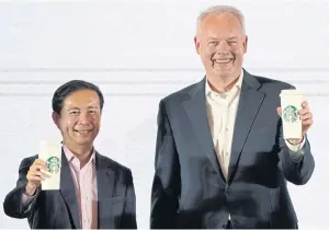  ?? REUTERS ?? Starbucks CEO Kevin Johnson, right, and Alibaba Group CEO Daniel Zhang hold Starbucks cups during a press conference in Shanghai yesterday.