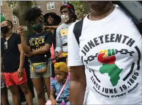  ?? AP FILE ?? People attend Juneteenth celebratio­ns in the Harlem neighborho­od of New York, on June 19. Recognitio­n of Juneteenth, the effective end of slavery in the U.S., gained traction after the police killing of George Floyd in 2020. But after an initial burst of action, the movement to have it recognized as an official holiday in the states has largely stalled.