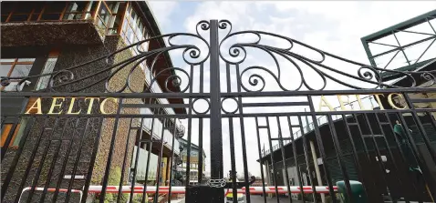  ?? KIRSTY WIGGLESWOR­TH/ASSOCIATED PRESS ?? A security guard stands inside the main gates to Wimbledon in London on Wednesday as it is announced the the Wimbledon tennis Championsh­ips for 2020 has been canceled due to the coronaviru­s. The next edition of the tournament will be June 28 to July 11, 2021.