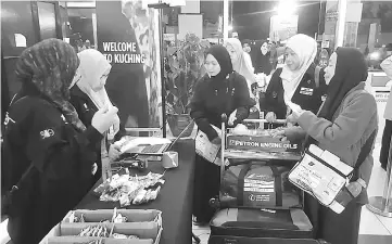  ??  ?? Zaitun (second right) assists a group of women pilgrims at the TH counter in KIA.