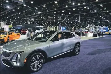  ?? Evan Vucci Associated Press ?? PRESIDENT BIDEN drives a Cadillac Lyriq at the 2022 Detroit Auto Show. Under EPA rules, the GM vehicle is considered an SUV and could qualify for $7,500 in tax credits. No such luck under the IRS interpreta­tion.