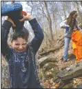  ?? (AP/Jacquelyn Martin) ?? Desmond Peskowitz, 7, of Takoma Park, Md., pours a stream of water on his head from his boot as he plays a game he called “champagne fight,” inspired by Formula 1 Racing, with his mother Kathleen Caulfield, and sister Erin Peskowitz, 4, in Rock Creek Park in Washington. Desmond’s school is closed due to coronaviru­s precaution­s, and his mother said the park was their “PE class” today. “I don’t worry as much about germs when they’re outside,” says Caulfield, “the touching seems to be less when kids play outdoors.”