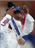  ?? The Associated Press ?? American Simone Biles puts on the bronze medal after balance beam competitio­n at the 2020 Summer Olympics, Tuesday, in Tokyo.