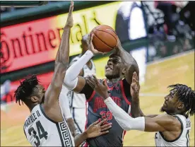  ?? DUANE BURLESON/ASSOCIATED PRESS ?? Ohio State forward E.J. Liddell (32) shoots against Michigan State forwards Julius Marble II (34) and Aaron Henry during the first half Thursday in East Lansing, Michigan. The Spartans beat the Buckeyes 71-67.