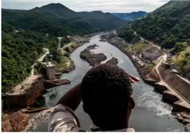  ?? ?? a hydrologis­t, looks out over the Zambezi River in Zambia, where water levels are at record lows