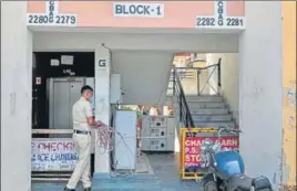  ?? RAVI KUMAR/HT ?? A cop sealing the entrance of a building in Sector 63 after a fresh case there on Thursday.