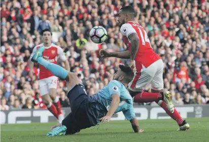  ??  ?? Swansea's Neil Taylor, left, clears the ball from Arsenal's Theo Walcott