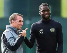  ?? — AFP ?? Another fling: Celtic manager Brendan Rodgers sharing a joke with midfielder Olivier Ntcham before the start of a training session in Glasgow yesterday. Celtic face Paris St Germain today.