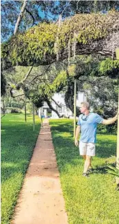  ?? TREVOR FRASER/ORLANDO SENTINEL ?? Real estate flipper Garth Bolton points out the custom poles at Jeno Paulucci’s Sanford home that support the branches of one of the property’s live oaks.