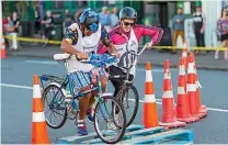  ?? SIMON O’CONNOR/STUFF ?? Above and below: The JetCharm retro bicycle race saw contestant­s navigate an obstacle course on a closedoff section of Egmont St.