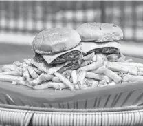  ??  ?? The Boom Boom Burger is on the menu at Space Cowboy, a poolside bar and restaurant at the Heights House Hotel.
