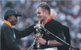  ??  ?? President Nelson Mandela hands Springbok captain Francois Pienaar the World Cup trophy after their victory against the All Blacks in 1995. Photo: Wessel Oosthuizen/Gallo Images