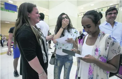  ?? Mona Al Marzooqi / The National ?? Al Yasmina Academy pupils and their families check out the GCSE results.