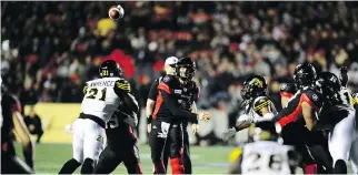  ?? SEAN KILPATRICK/THE CANADIAN PRESS ?? Redblacks quarterbac­k Trevor Harris unloads a pass while under pressure from the Tiger-Cats defence Friday in Ottawa. Harris threw for 341 yards in the Redblacks’ 35-31 victory.