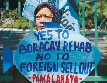  ?? AP FOTO ?? CONCERNS: An activist displays a placard outside the DENR office in Manila to protest the closure of the island of Boracay and the constructi­on of a Chinesebac­ked casino.