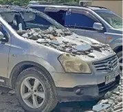  ?? (AFP) ?? Damaged cars are seen outside a building in Honiara on Tuesday after a strong earthquake