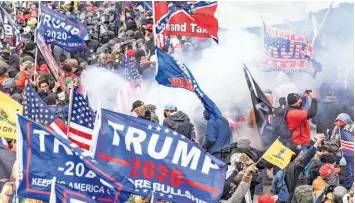  ?? Shuttersto­ck / lev radin ?? Smoke rises after police used pepper-spray ball guns against Pro-Trump protesters rally January 6 around the Capitol building before they breached and overrun it.