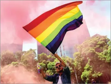  ??  ?? A lone reveller flutters a rainbow flag during the celebratio­n of gay pride in Mexico City on Saturday. Some 200 people broke virus containmen­t rules and marched along Paseo de la Reforma, the main avenue in Mexico City.