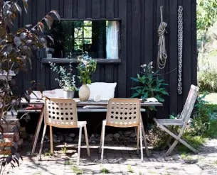  ??  ?? SUPPLEMENT GARDEN FURNITURE with more durable pieces from the house during a dry summer spell. Here (left), some inexpensiv­e moulded plastic chairs have migrated outdoors to cater for guests and join the all-weather teak pieces