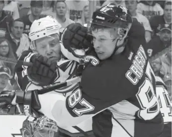  ?? GENE J. PUSKAR/THE ASSOCIATED PRESS ?? The Blue Jackets’ Jack Johnson tussles with the Penguins’ Sidney Crosby in front of the Columbus goal.