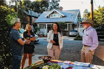  ?? Yalonda M. James/The Chronicle ?? During the campaign, Sheng Thao (center) talks with Peter Barthmaier (left), Chris Lu and Richard Unger at a meet-and-greet event in Oakland’s Rockridge neighborho­od.