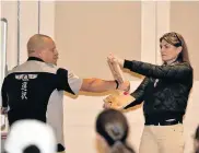  ?? Picture: EUGENE COETZEE ?? BREAKING THROUGH: Mark Grobbelaar demonstrat­es breaking a board held by Debbie Millar at the Woman INpowermen­t workshop at the Boardwalk