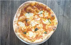  ?? J.P. MOCZULSKI FOR THE TORONTO STAR ?? Italian tradition dictates margherita pizzas be soft and elastic, with a raised lip and basil.