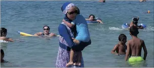  ?? PICTURE: REUTERS ?? A woman wearing a burkini walks in the water on a beach in Marseille, France, a day after the country’s highest administra­tive court suspended a ban on full-body burkini swimsuits.