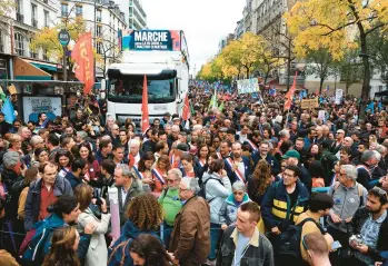  ?? AURELIEN MORISSARD/AP ?? Thousands of protesters Sunday take to the streets of Paris in a show of anger against rising prices, cranking up pressure on President Emmanuel Macron. The march was organized by left-wing opponents of Macron. Transporta­tion strikes called for Tuesday threaten to dovetail with wage strikes that have already hobbled fuel refineries and depots.