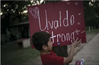 ?? WONG MAYE-E — THE ASSOCIATED PRESS ?? Eight-year-old Jeremiah Lennon at a sign he helped decorate and place on a utility pole in front of his home on May 28in Uvalde, Texas. Lennon was in a classroom next to the room where three of his friends were slain.