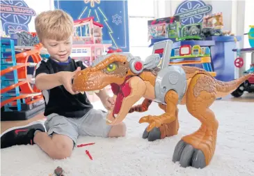  ?? PHOTOS BY AP ?? A boy explores a Jurassic World Jurassic Rex at the Walmart Toy Shop event in New York.