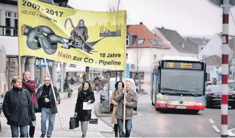  ?? RP-FOTO: MATZERATH ?? Mitglieder der Initiative­n „Stopp Bayer-COvestro-Pipeline“tragen das neue Banner durch Monheim.