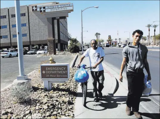  ?? K.M. Cannon Las Vegas Review-Journal @KMCannonPh­oto ?? Carlos Sanchez, 61, left, and his son, Jacob Edward Delgado, 23, walk to a bus stop Friday after Sanchez’s release from North Vista Hospital’s psychiatri­c ward.