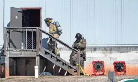  ?? AP-SCOTT ROGERS ?? Two Hall County Firefighte­rs enter a back door Jan. 29 at Foundation Food Group in Gainesvill­e, Ga., the day after six people were killed following a liquid nitrogen leak at the plant.