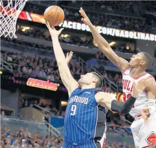  ?? STEPHEN M. DOWELL/STAFF PHOTOGRAPH­ER ?? Magic C Nikola Vucevic (9) has his shot blocked by Bulls G Kris Dunn during Friday’s game at Amway Center. Vucevic finished with 14 points as the Magic suffered their worst loss of the season.