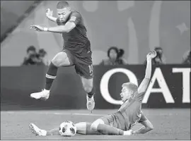  ?? Christophe Simon AFP/Getty Images ?? FRANCE’S Kylian Mbappe leaps over Belgium midfielder Kevin De Bruyne at St. Petersburg. France reached the final for the third time in six World Cups.