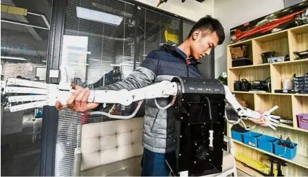  ??  ?? Worthy invention: Song Jiyuan checking a robot that can interpret sign language at a makerspace of the National University Science Park of Henan Province in Zhengzhou, the capital of central China’s Henan Province. The robot, developed by Song, a...